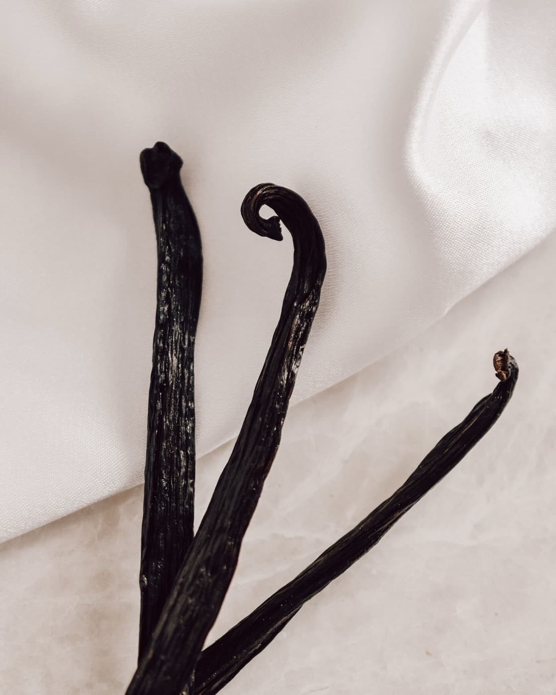 Cured vanilla beans on white cloth